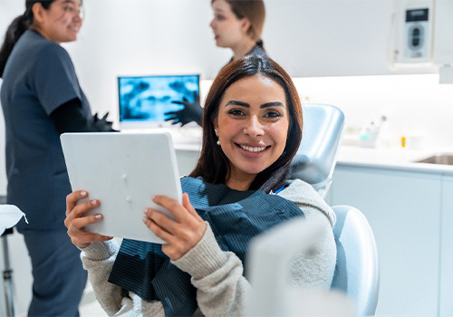 Woman smiling while holding handheld mirror