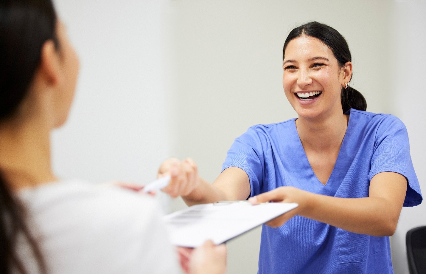 Woman smiling while handing patient form
