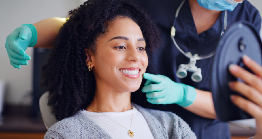 Dentist showing patient shiny white smile in mirror