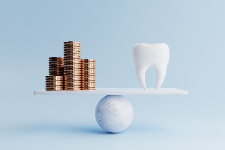 A tooth and coins on a balance
