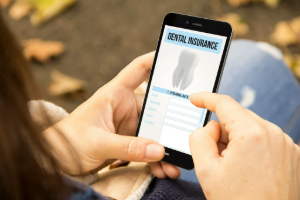 Woman looking at dental insurance form on phone